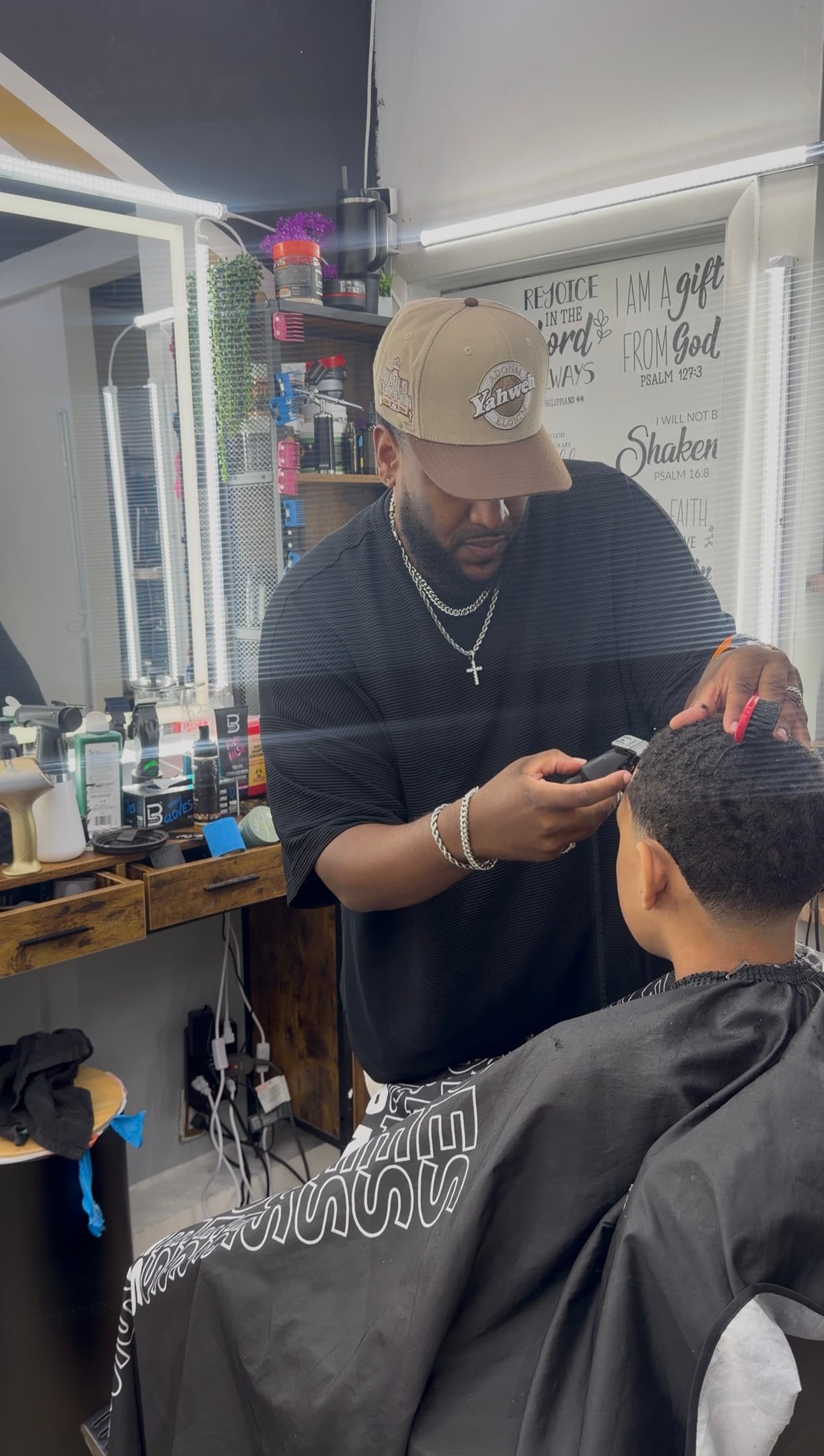 Barber cutting a fade on a young client with waves at Soto Time Cuts